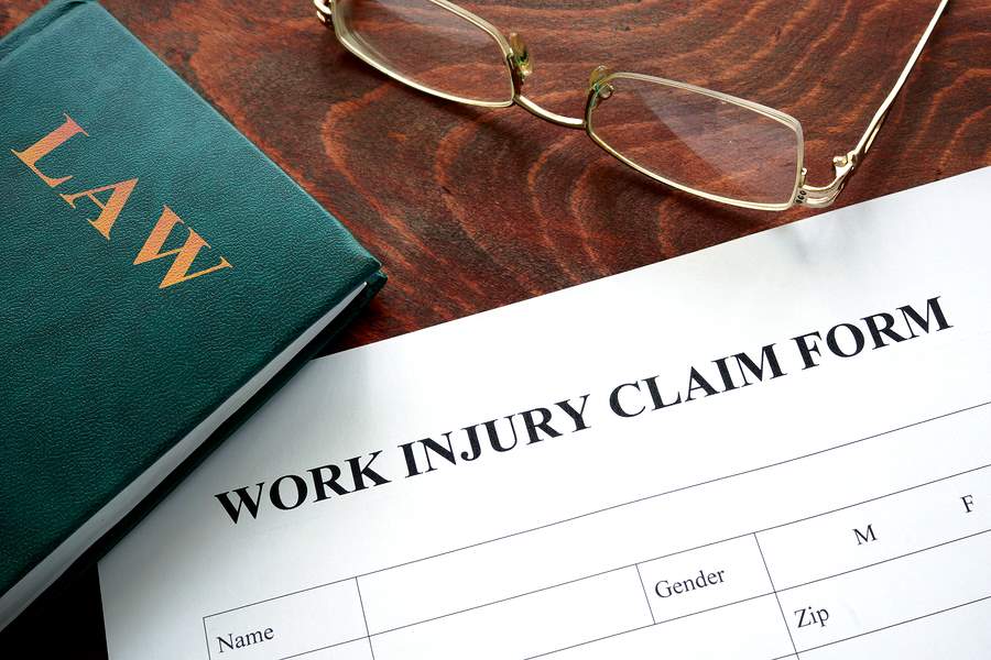 work injury claim form next to law book on table