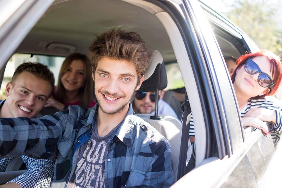 Young people having vacation enjoying fun driving car