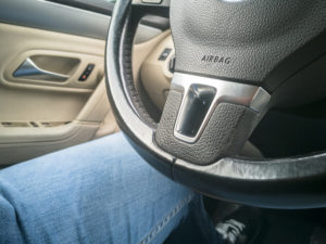 Airbag located on the steering wheel of a modern car with man inside