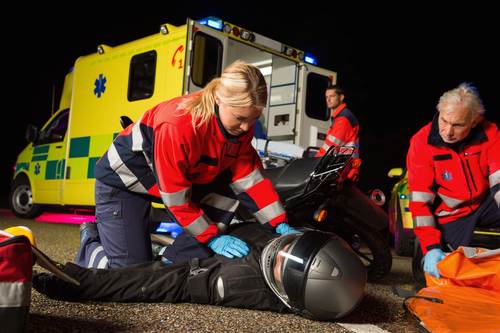 Paramedics treating a motorcycle accident victim at the crash scene.