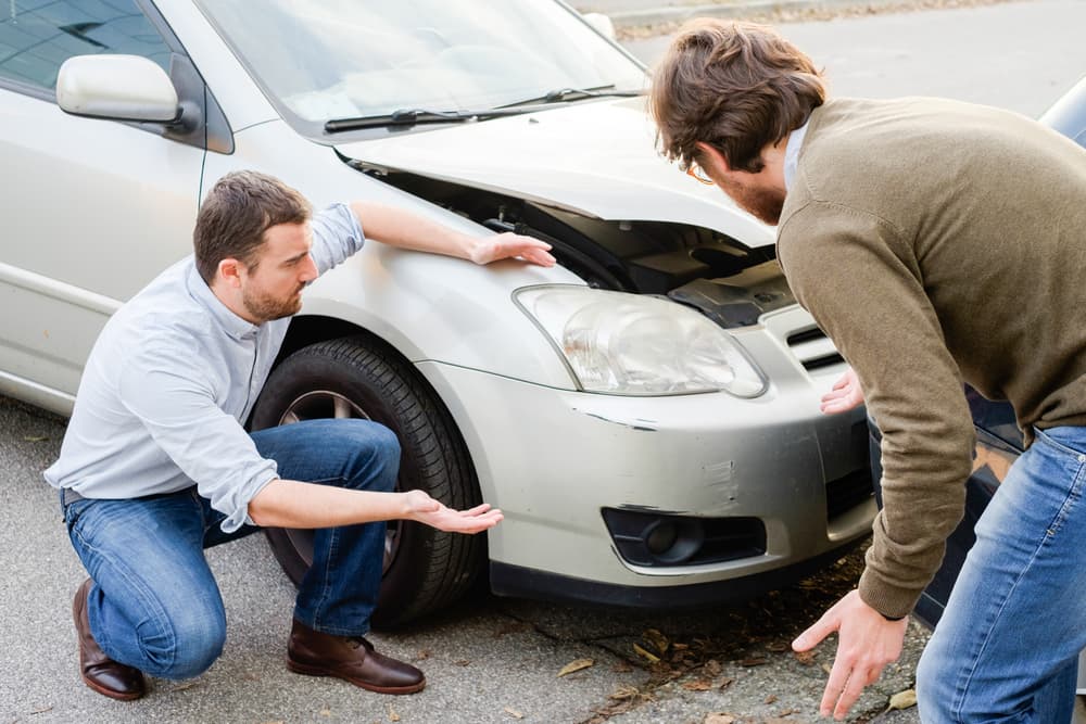 Dos hombres discutiendo tras un accidente automovilístico en la carretera