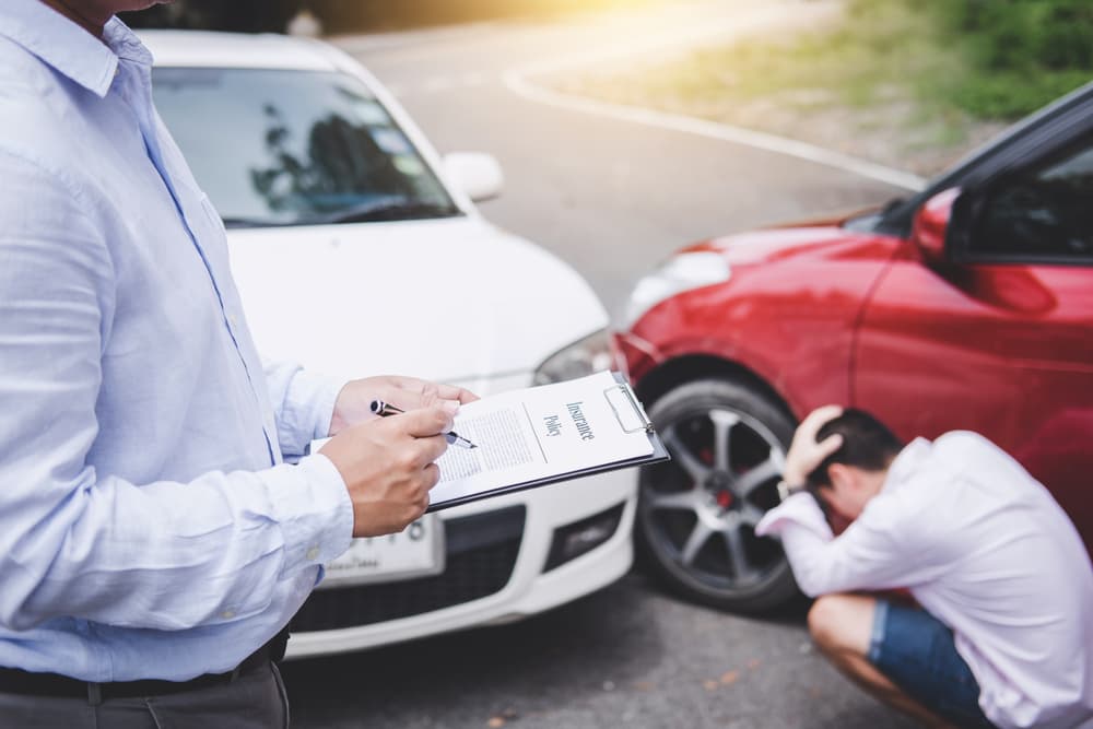 Visualizing a traffic accident and insurance: Insurance agent diligently processing a car accident claim on a report form.