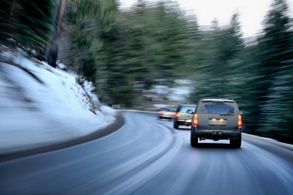 Dangerous mountain road during a winter evening, prone to high traffic.