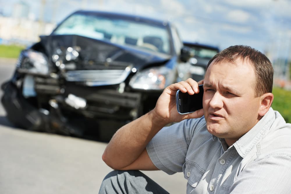 Un hombre angustiado habla por teléfono después de una colisión automovilística en una carretera de la ciudad de Kansas.