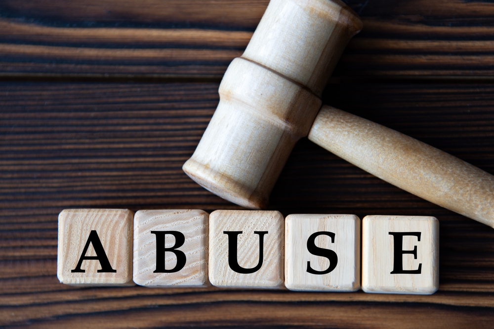 photo of white gavel and wooden blocks with the word abuse on it