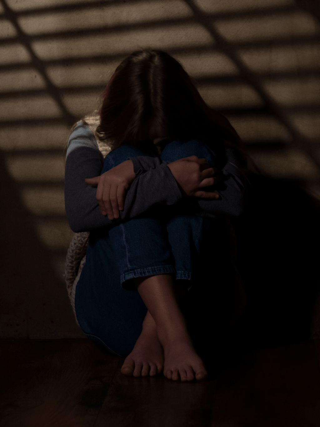 teen girl hiding in the dark, face on knees