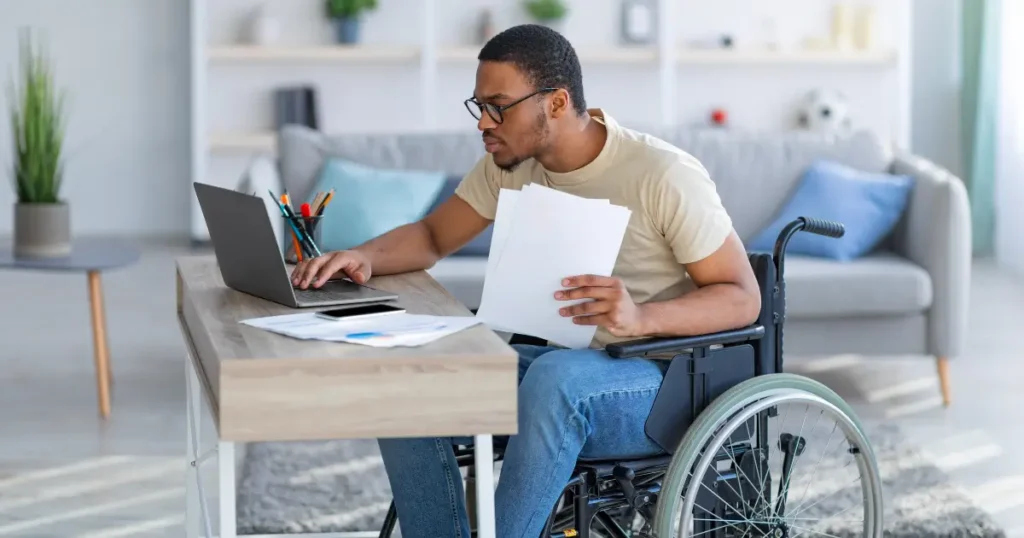 man in wheelchair using computer